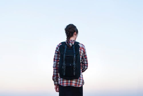 Woman Wearing Plaid Shirt Carrying a Backpack