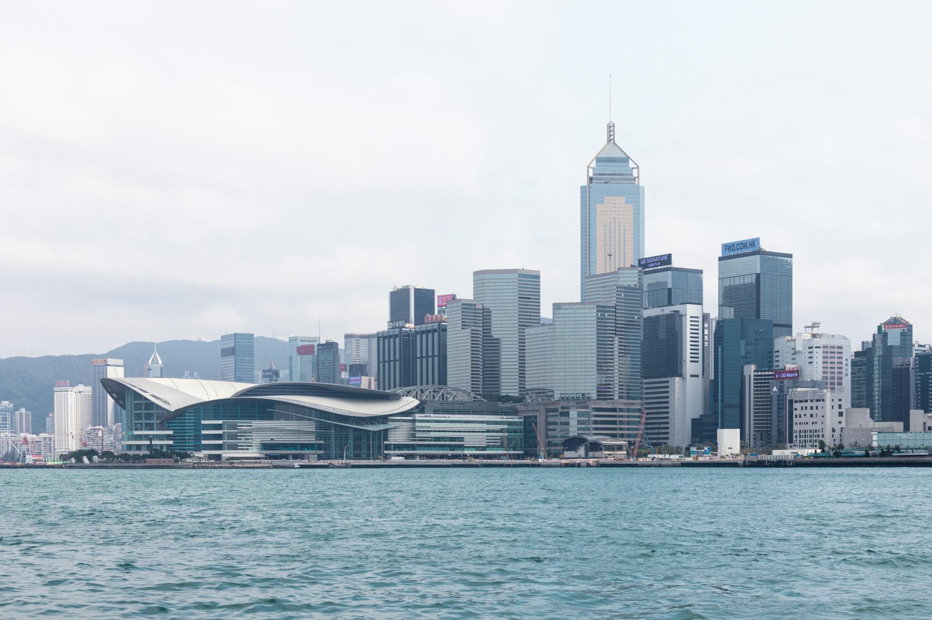 Scenic view of Hong Kong skyline with iconic skyscrapers and waterfront harbor.