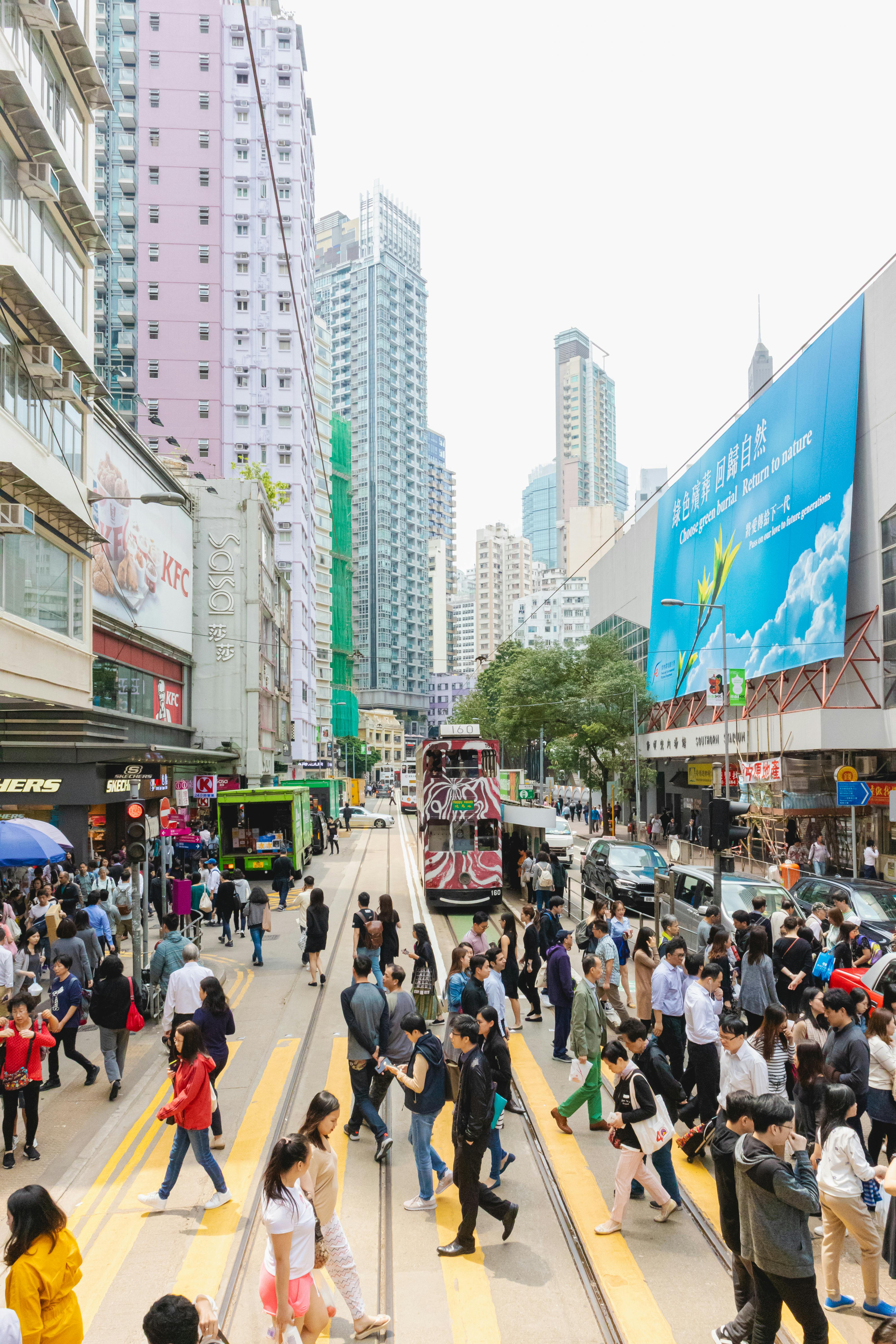 Free Bustling Hong Kong street scene with people crossing and a tram on a busy day. Stock Photo