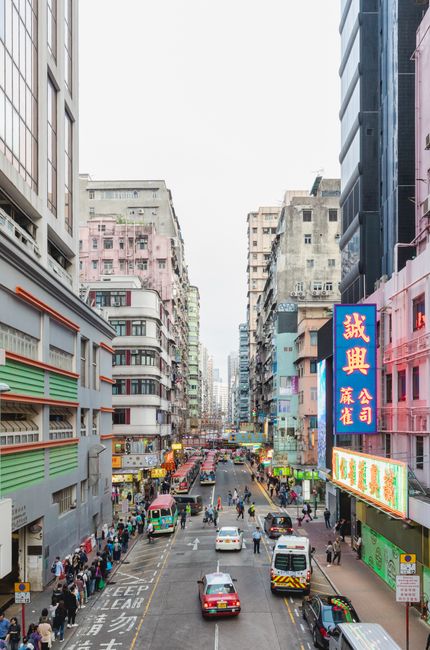 A vibrant scene of a busy street in Hong Kong with colorful signs and pedestrians.