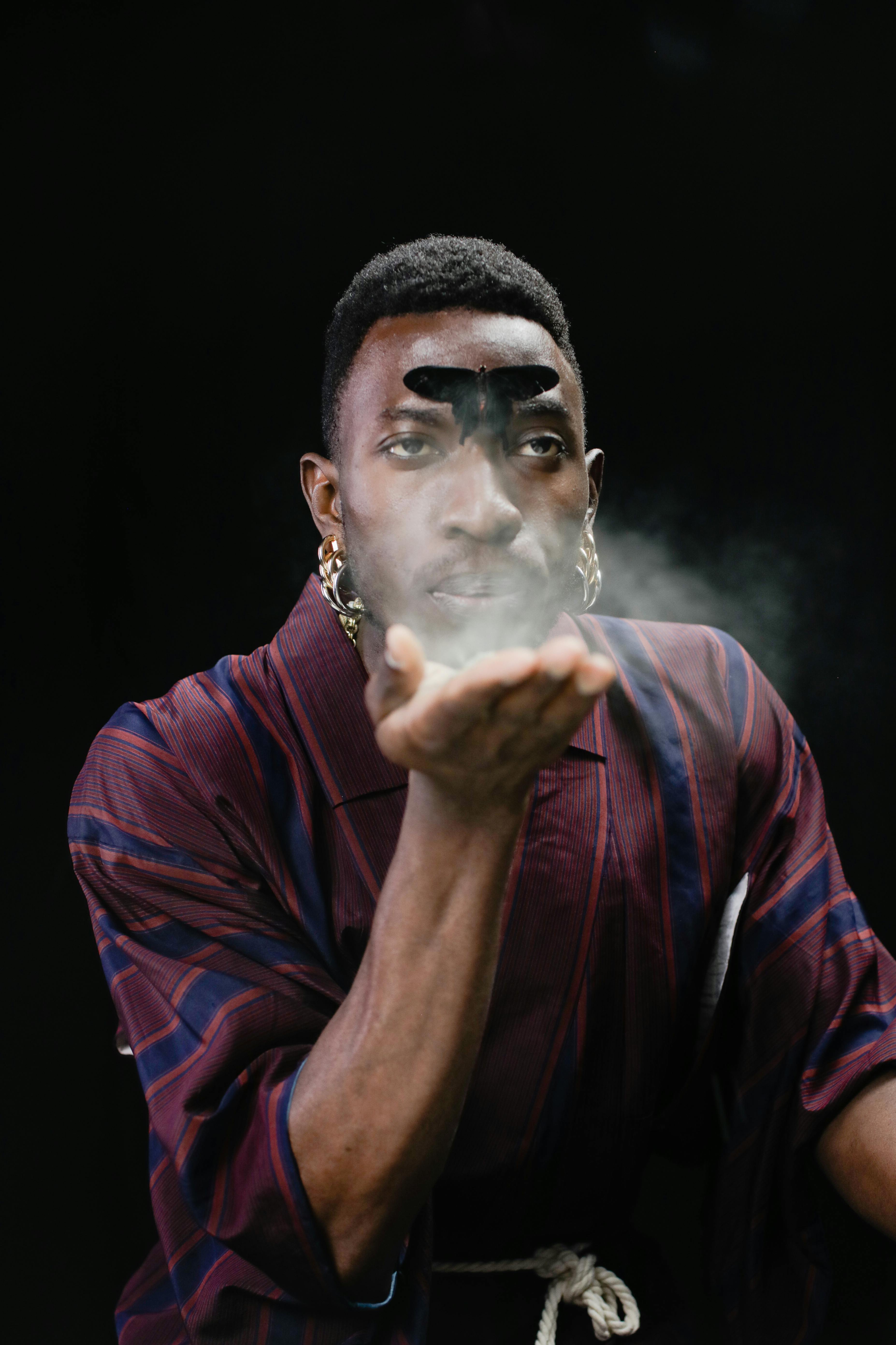 man blowing white powder on his hand