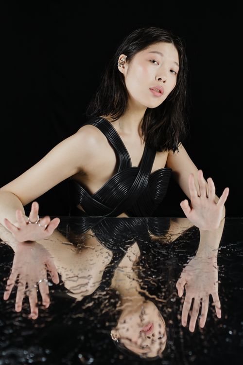 Free Artistic studio portrait of woman with reflections on glass in dramatic light. Stock Photo