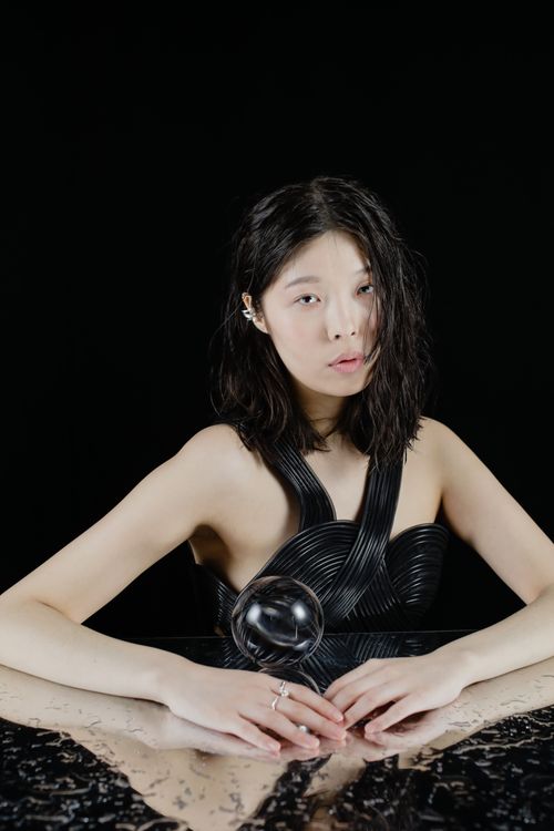Free Elegant studio portrait of a woman with a glass sphere, featuring a modern artistic style. Stock Photo