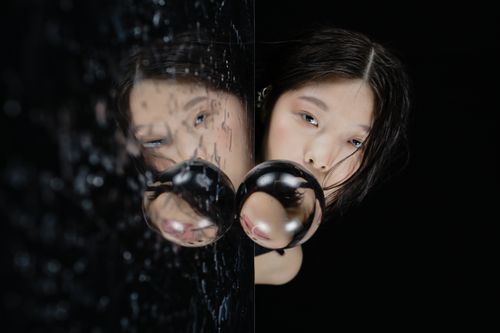 Free A close-up portrait of a woman gazing through a crystal ball, creating a mysterious and reflective mood. Stock Photo