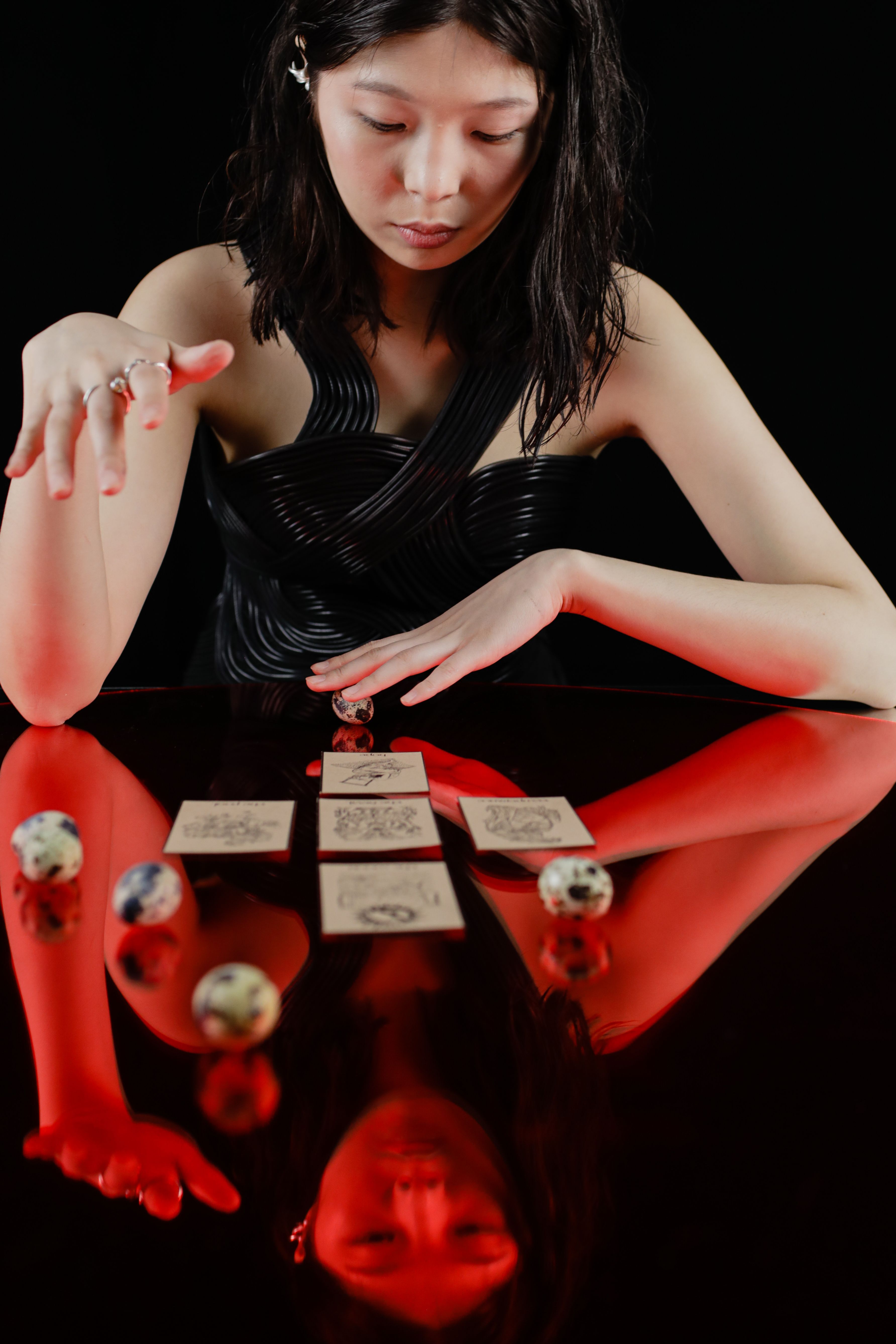 Asian woman performing tarot reading, reflecting a mystical atmosphere.