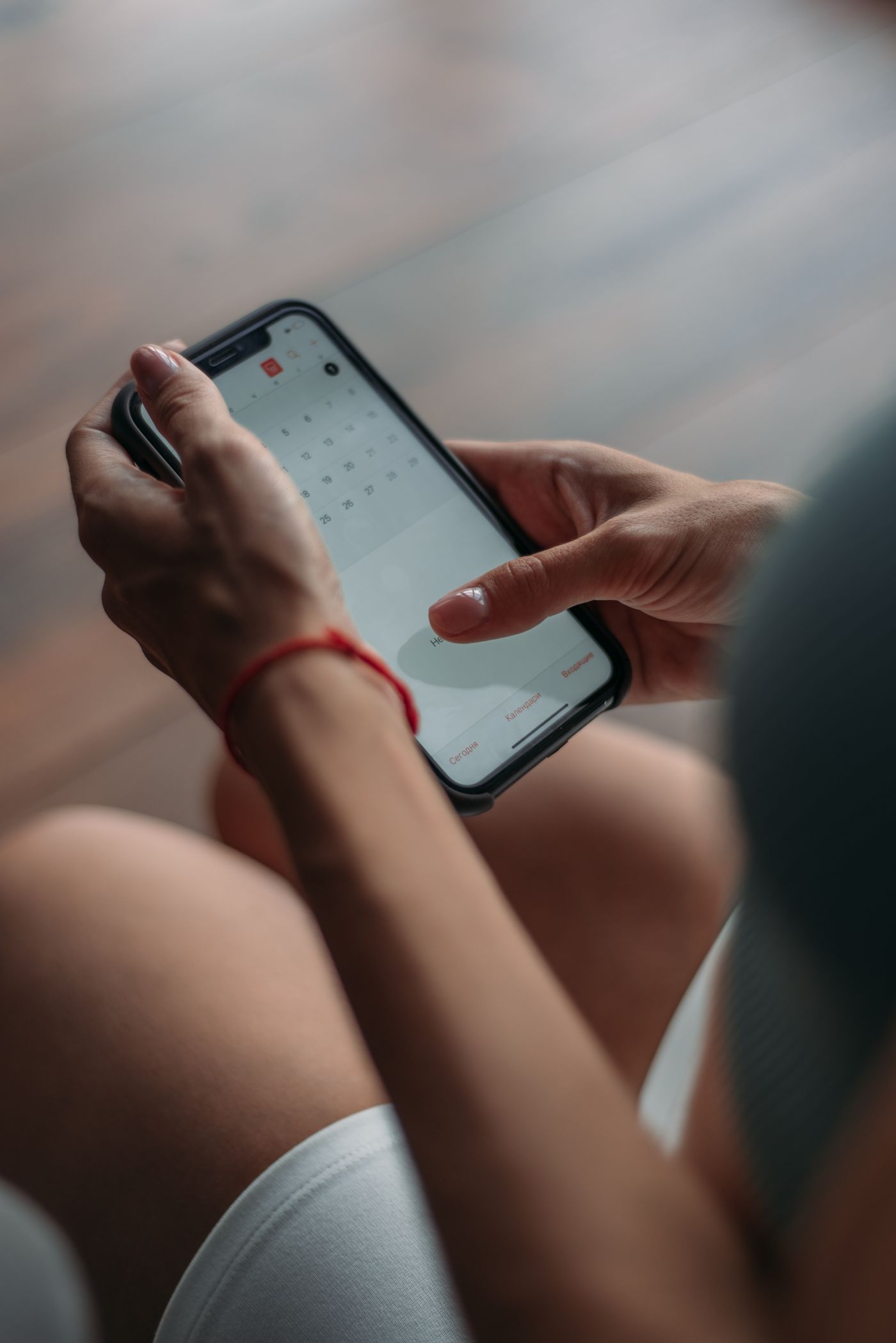 Coach sportif utilisant un smartphone pour consulter son agenda de réservations