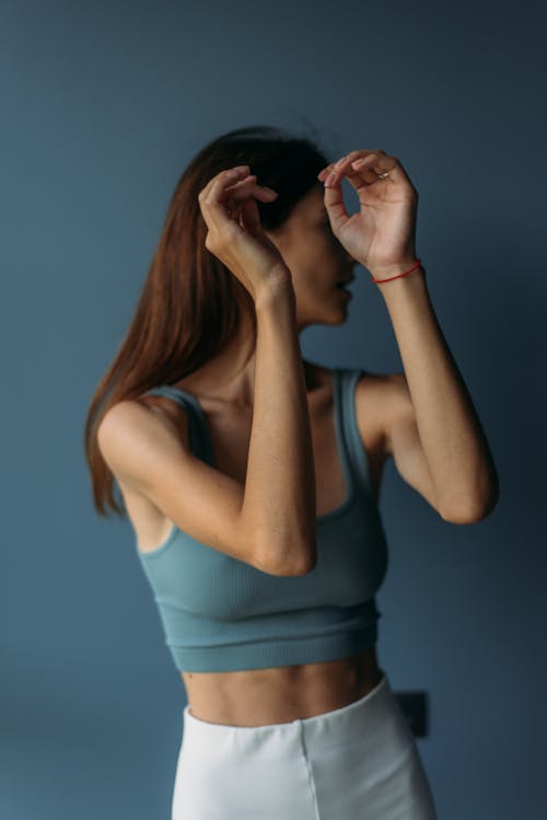 Woman in Blue Tank Top with Arms Raised