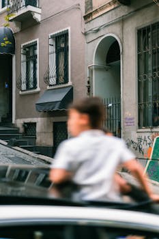 Urban scene with blurred child on cobblestone street, highlighting city architecture.