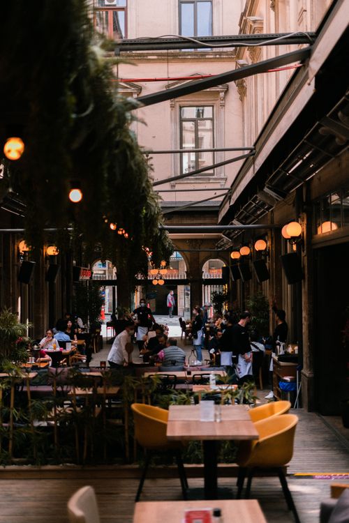 Free Cozy outdoor coffee shop with evening lights and bustling social scene captured in a vibrant urban atmosphere. Stock Photo