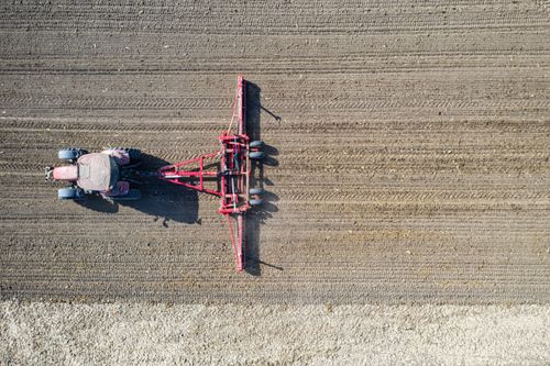 Free Drone shot of a tractor plowing a field in rural Plainview, Minnesota. Stock Photo