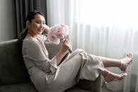Woman in White Long Sleeve Dress Sitting on Gray Couch