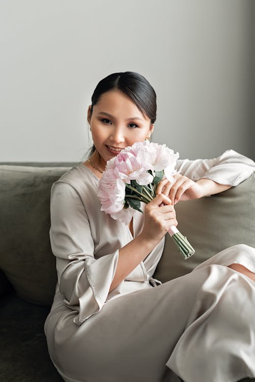 Free Woman in White Long Sleeve Shirt Holding Pink Rose Bouquet Stock Photo