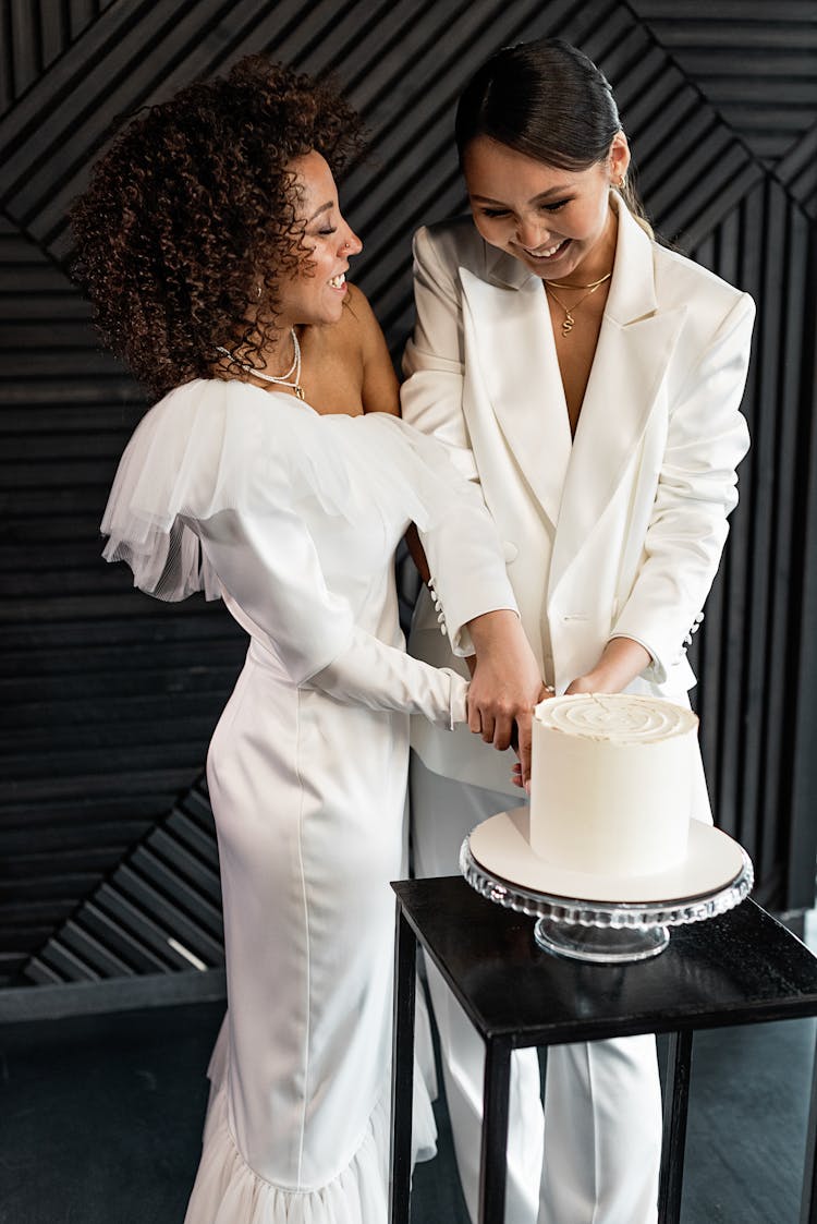 A Happy Newlywed Couple Cutting A Wedding Cake Together