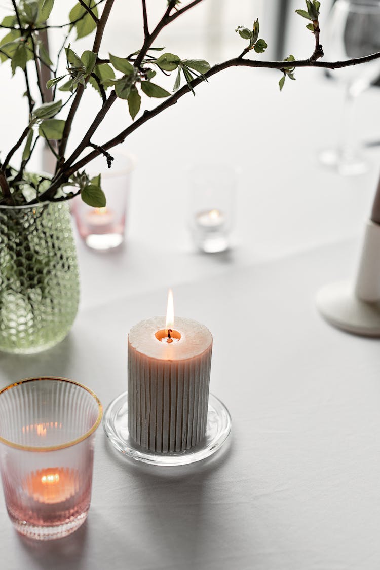 Lighted Candle Beside A Glass Vase