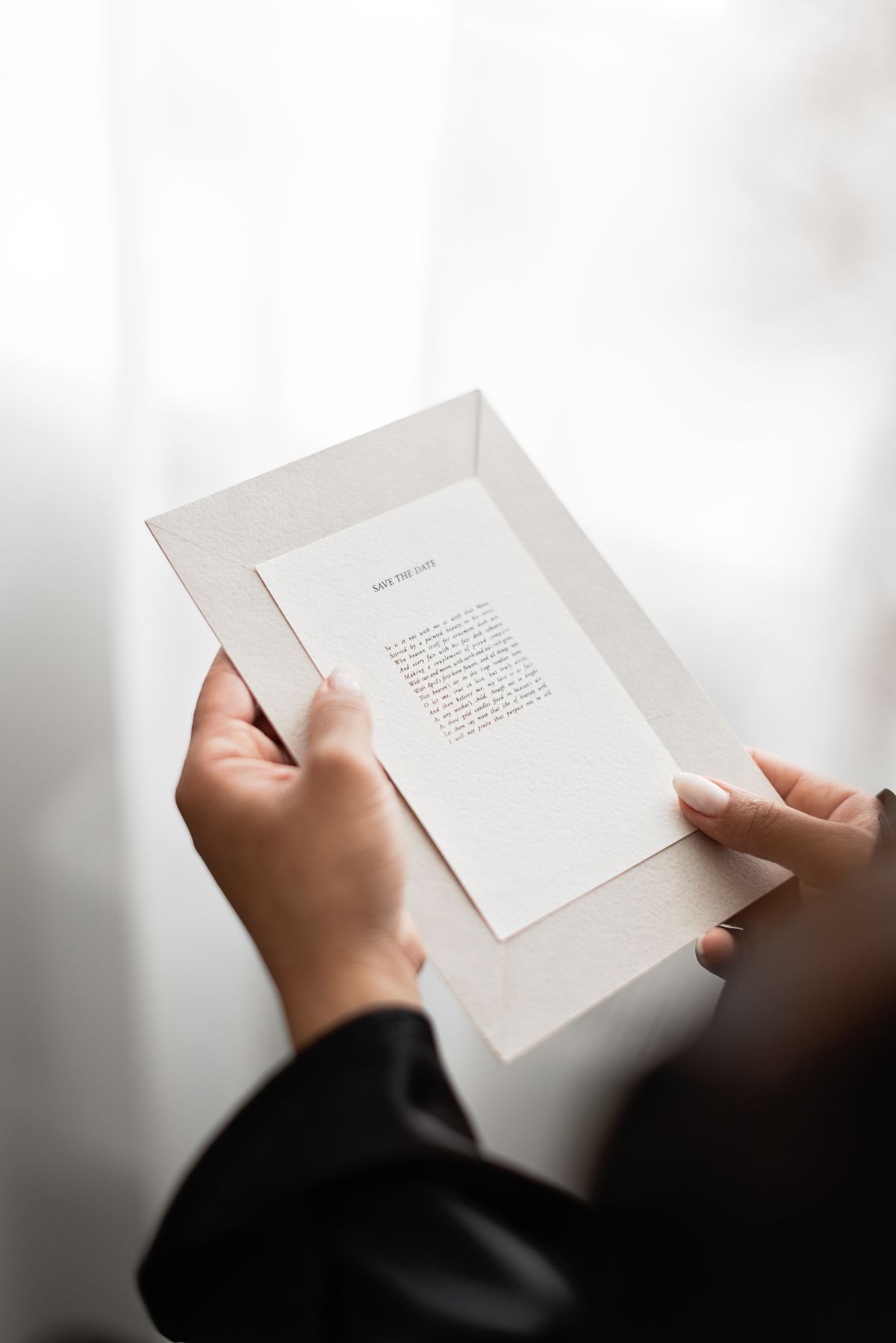 Manos sosteniendo una invitación elegante
