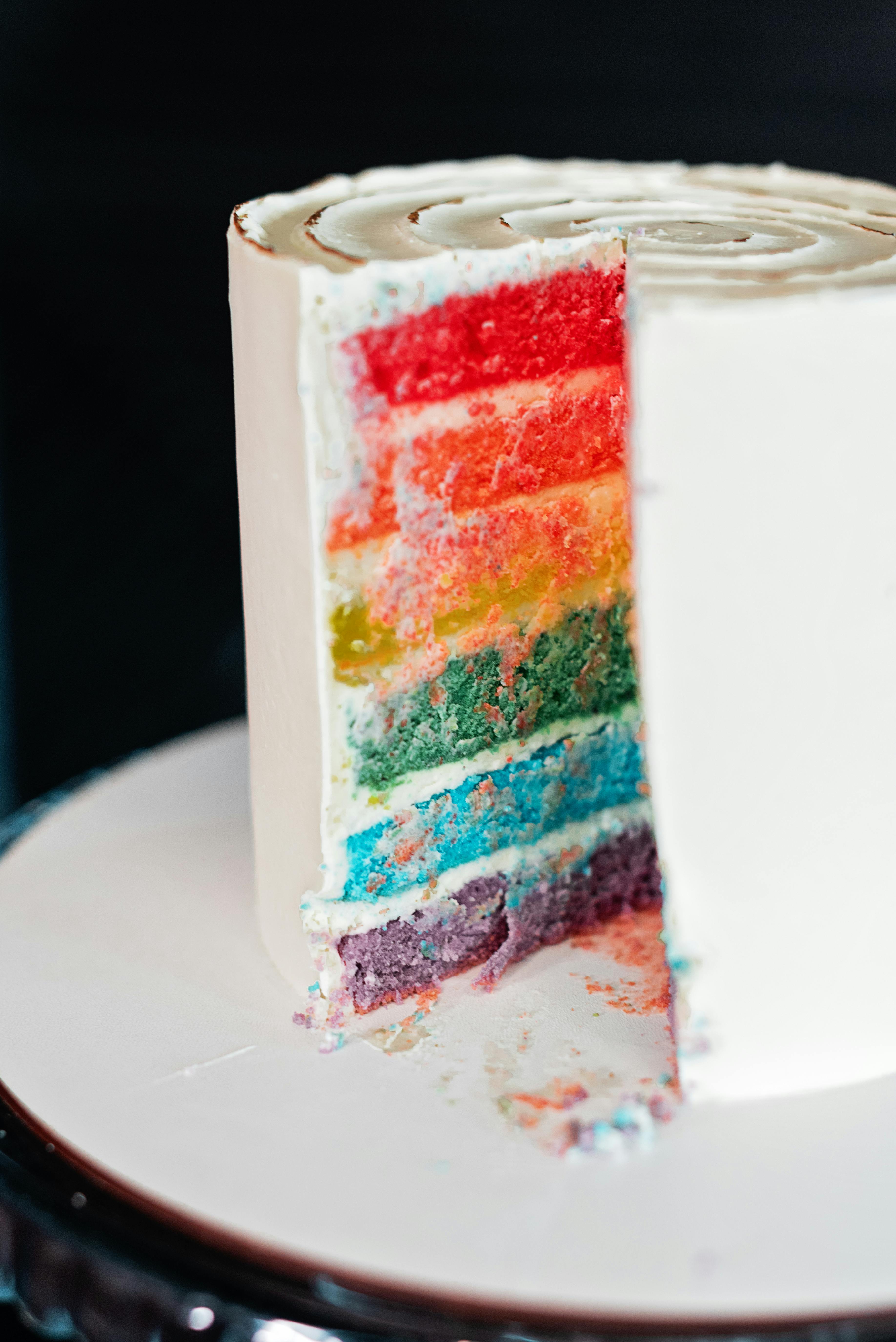 Deliciously colorful rainbow cake with creamy icing, vibrant layers exposed.
