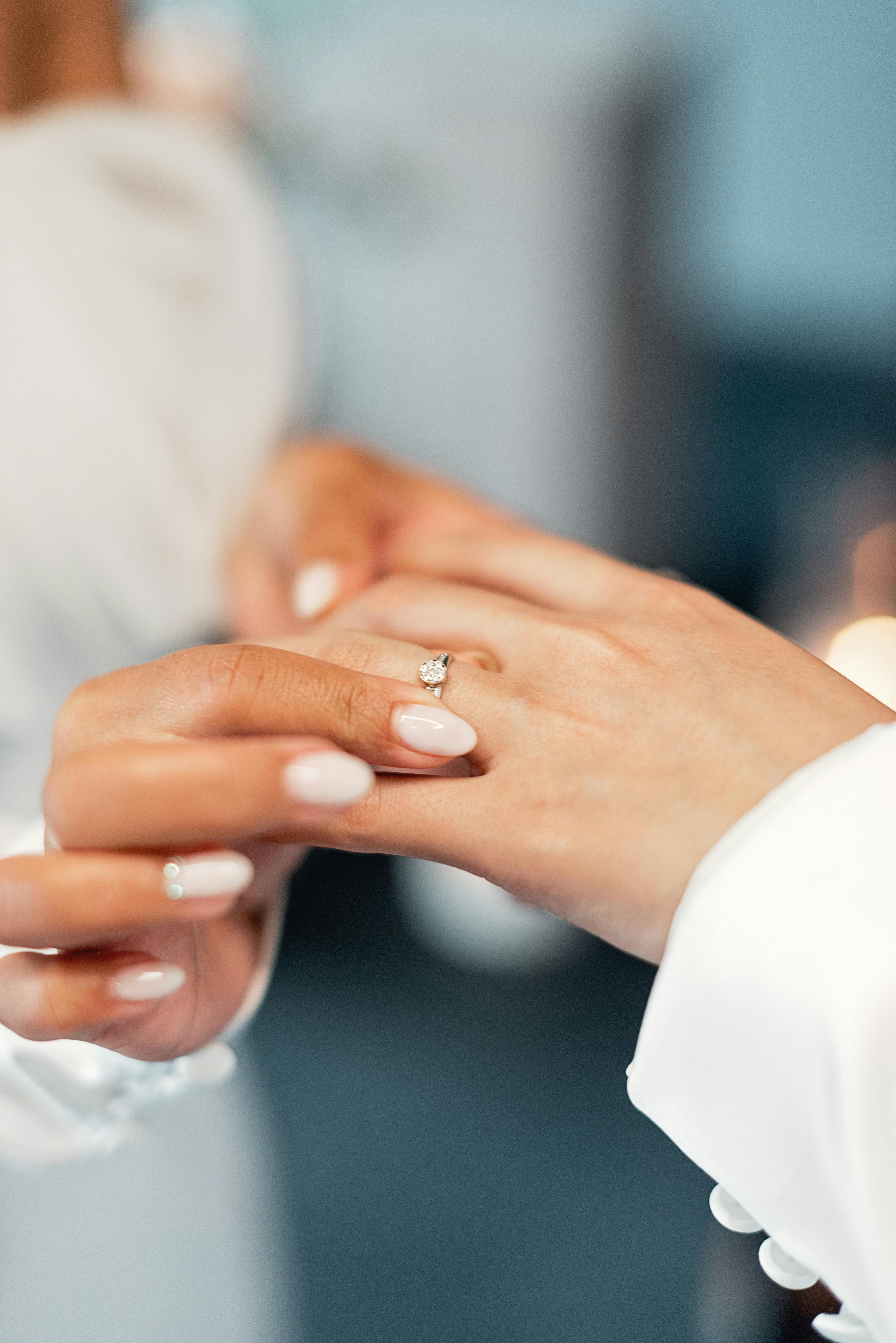 woman putting on an engagement ring