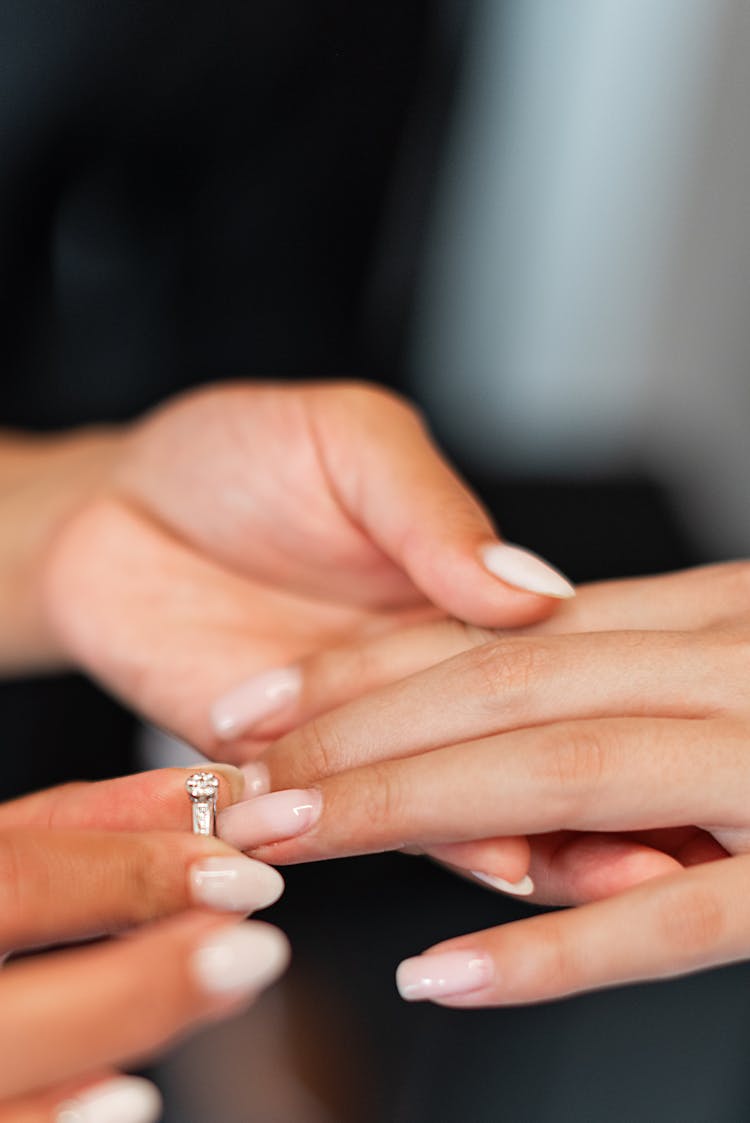 Person Putting On A Wedding Ring To Another Person