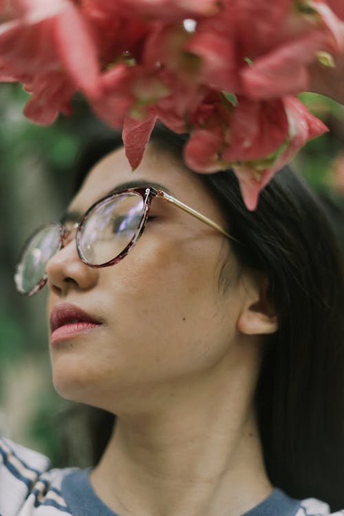 Portrait of a Woman with Eyeglasses Near Flowers