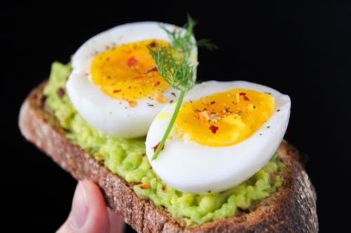 Free Нарезанное яйцо поверх зеленого салата с хлебом Stock Photo