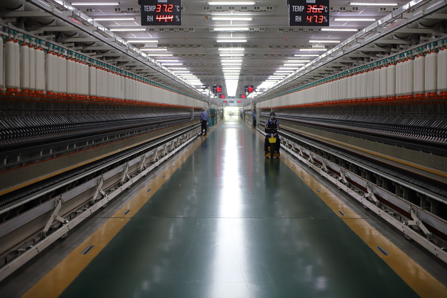 Spacious textile machinery hallway in an Indian industrial plant showing advanced equipment.