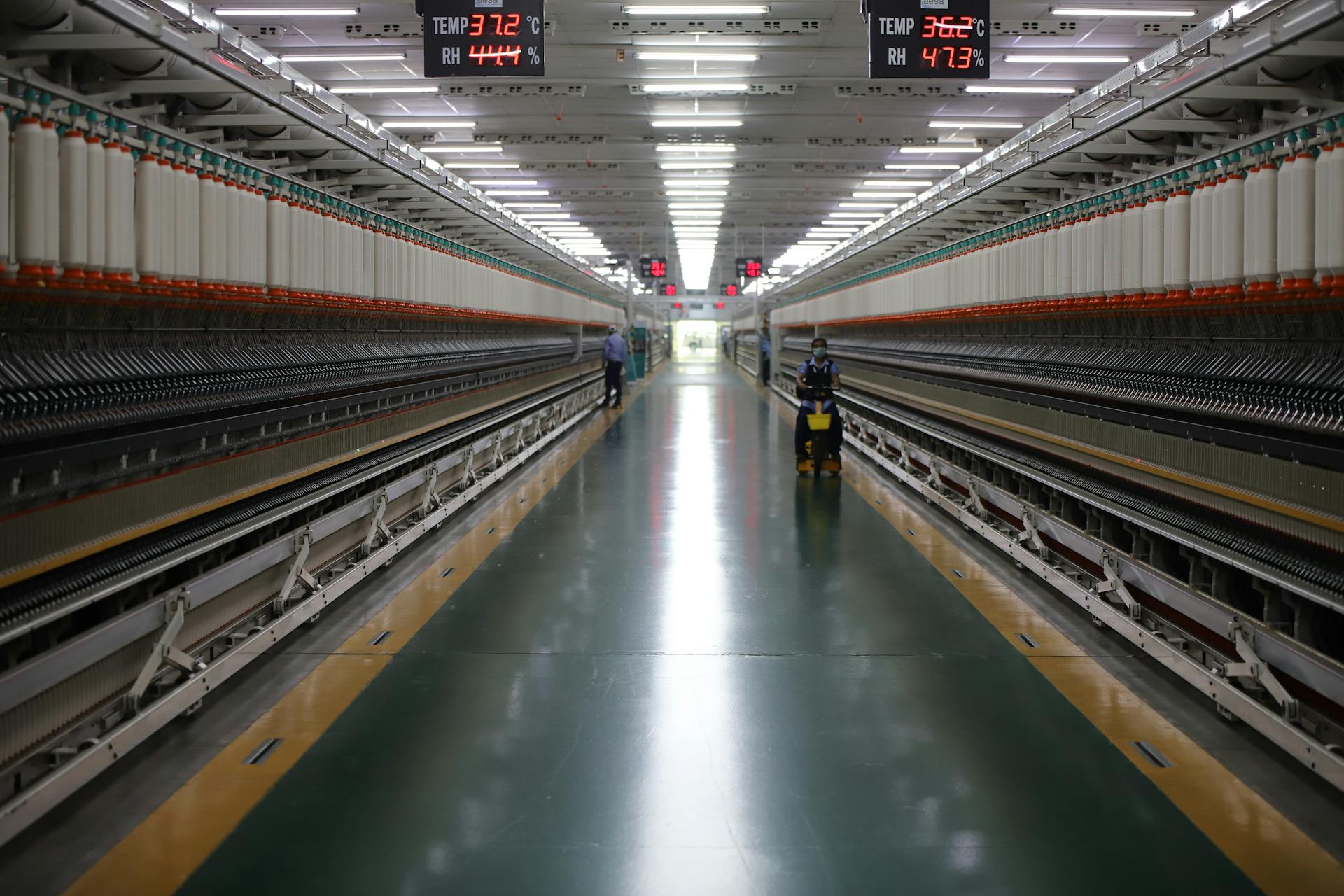 Spacious textile machinery hallway in an Indian industrial plant showing advanced equipment.