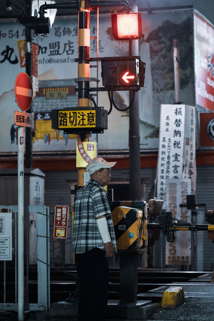 Man Waiting On Railway Crossing In City