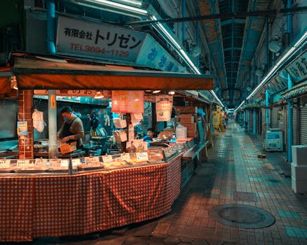 A vibrant Japanese street market scene at dusk, featuring a busy vendor preparing food under warm lights.