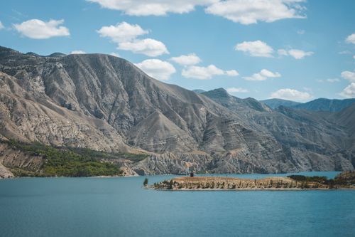 Free Stunning landscape of Tortum Lake and surrounding mountains in Erzurum, Turkey, under a bright blue sky. Stock Photo