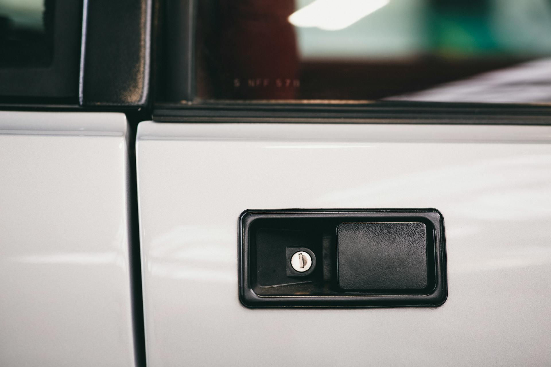 Detailed close-up of a vintage car door handle with lock mechanism.