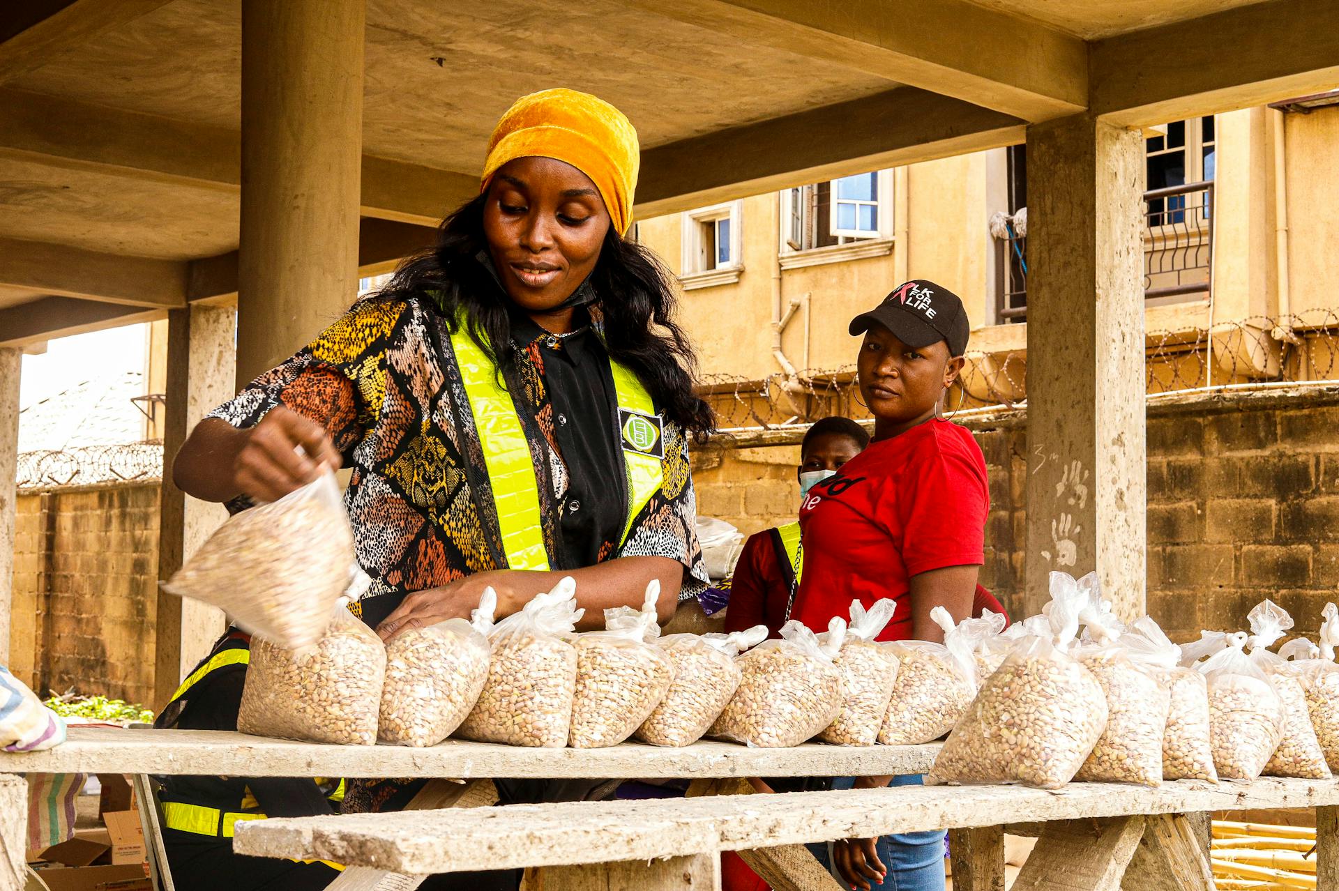 Woman on a Street Market Putting Plastic Bags with Dry Food on a Table