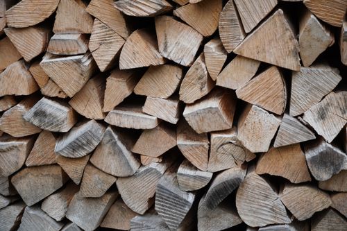 Free High-resolution image of stacked and chopped firewood ready for use. Stock Photo
