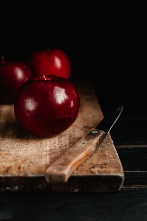 Free Close-up of shiny red apples on a rustic wooden board with a knife. Stock Photo