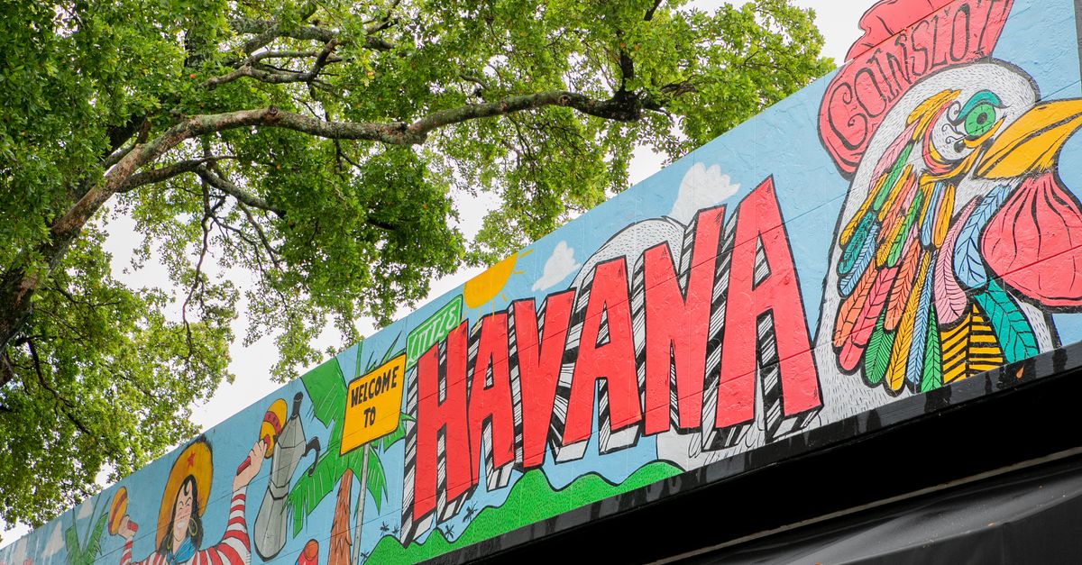 Vibrant mural in Havana featuring colorful rooster and lush greenery.