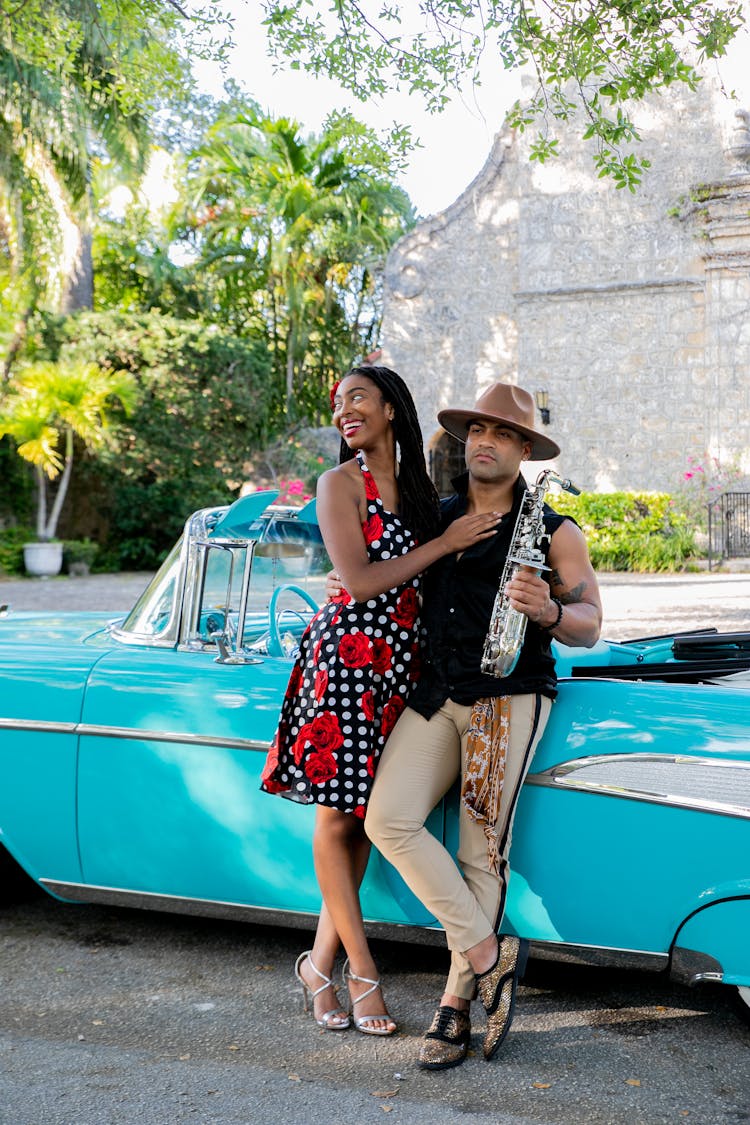 A Couple Leaning On The Car