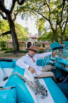Stylish man with saxophone in a classic convertible enjoying a sunny day outdoors.