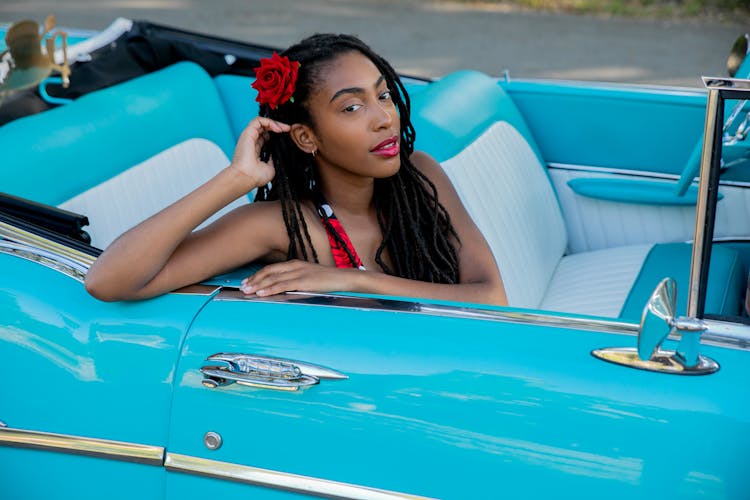 Woman With A Rose Sitting In A Blue Car