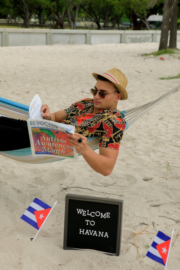 A Man Reading A Newspaper On A Hammock