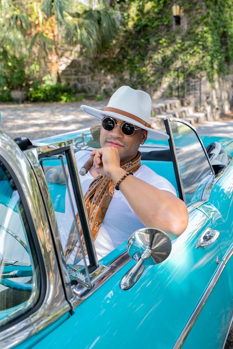 A Man In A Car Smoking A Cigar 