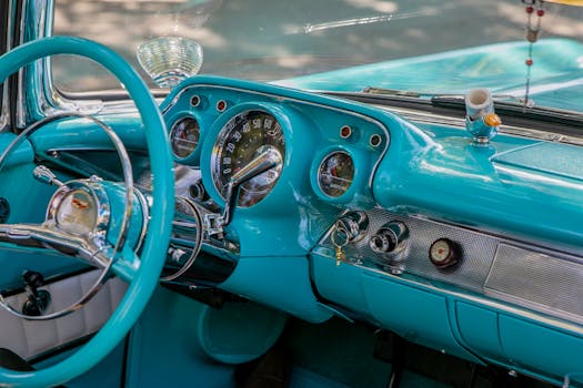 Detailed view of a classic car's turquoise interior and retro dashboard.