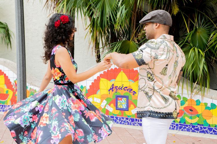 Pareja dominicana bailando bachata sensual con vestido floral tropical