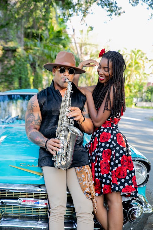 Smiling Woman by Man Playing Saxophone