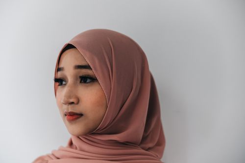 Free Close-up portrait of a woman wearing a pink hijab, showcasing graceful elegance. Stock Photo