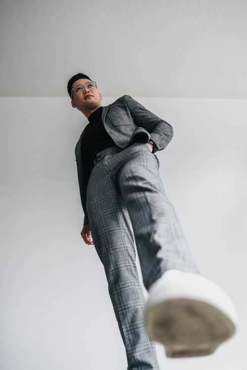Free Low angle studio shot of a stylish man posing in a blazer and plaid trousers. Stock Photo