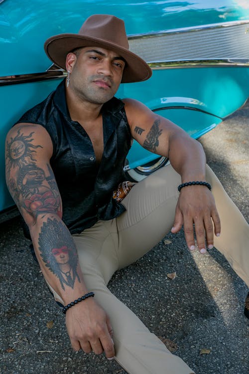 Man with a Brown Hat Sitting on the Ground