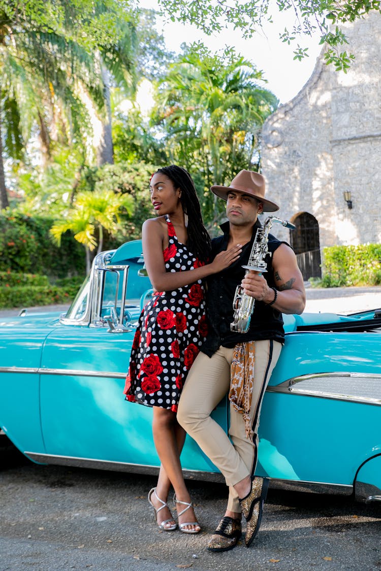 A Man Holding Saxophone With His Woman