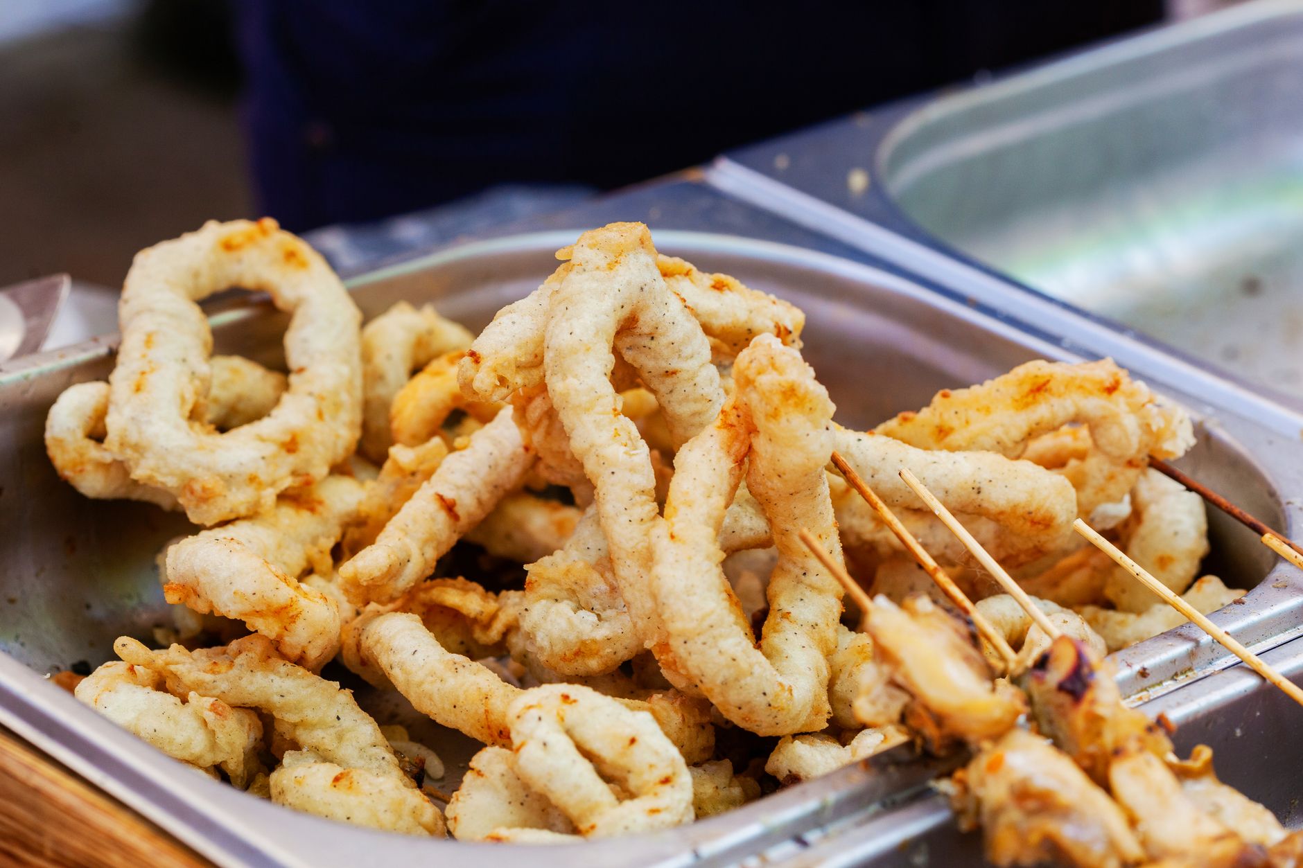 Fried calamari steaks on a platter with lemon wedges