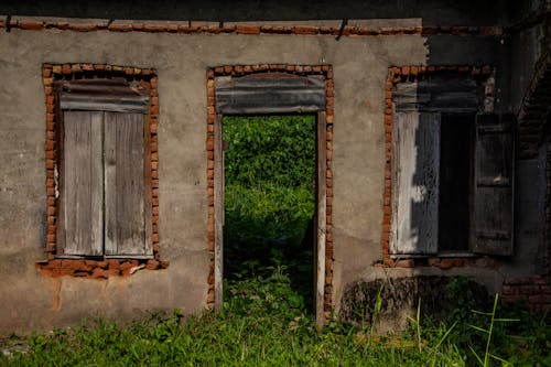 Abandoned Concrete House with Broken Wooden Windows 