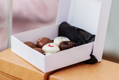 Free Delicious assorted chocolate donuts in an elegant gift box, perfect for dessert or gifting. Stock Photo
