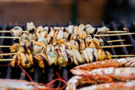 Close-up of assorted seafood skewers grilling on a hot BBQ, perfect for summer meals.